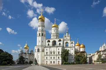 Fototapeta na wymiar MOSCOW, RUSSIA-AUGUST, 4, 2021: the white-stone high bell tower of Ivan the Great with golden domes on Cathedral Square on a bright sunny summer day