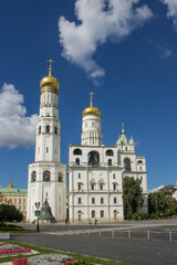 view of the white-stone bell tower of Ivan the Great with golden domes in the Kremlin on Sobornaya Square on a bright sunny summer day in Moscow Russia