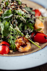 Closeup on shrimp and arugula salad with tomatoes and parmesan