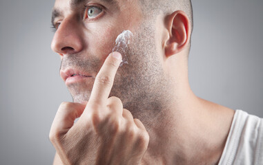 Fototapeta premium Caucasian man applying face cream.