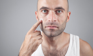 Caucasian man applying face cream.