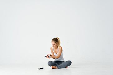 Fototapeta premium sportive woman sitting on the floor dumbbell in hands charging motivation energy exercise