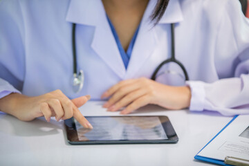 Asian women doctor  working and analyzing x-ray images  at  hospital office