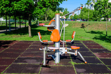 Outdoors fitness device machine in a city park for sport and activities, in a sunny spring day, in...