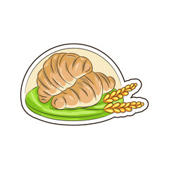 croissants and ears of wheat are on a plate
