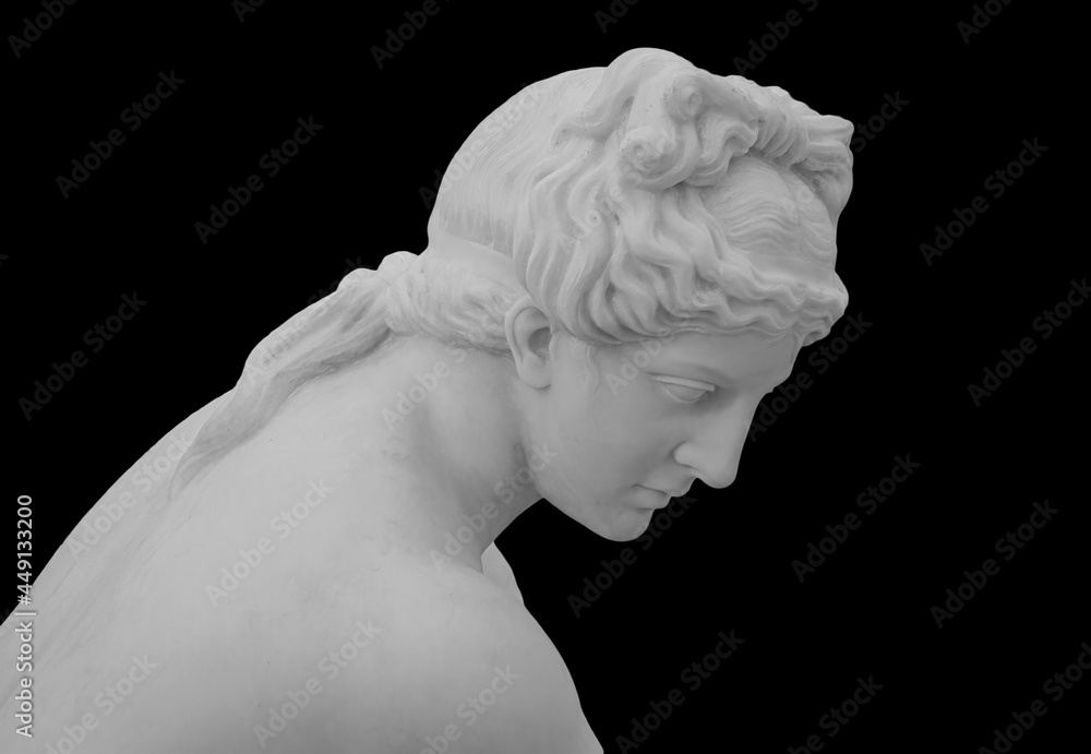 Wall mural Ancient white marble sculpture head of young woman. Statue of sensual renaissance art era woman antique style. Face isolated on black background