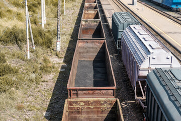Obraz premium Railway freight cars on rails. Transportation of coal in freight wagons. View from above.