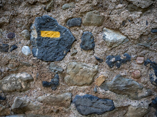 stone wall texture with yellow hiking trail marking