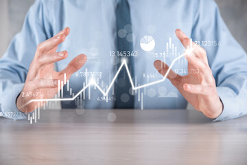 Businessman in hand hold banking business finance graph and invest in stock market investment point,economic growth and investor concept.analysis virtual stock market chart,analyze by use technology