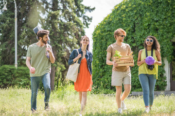 Fototapeta premium Young people walking on summer picnic in park