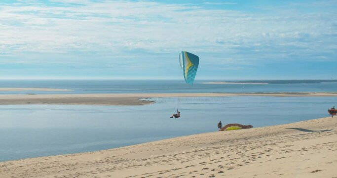 Paragliders Paragliding At Dune Of Pilat (Grande Dune du Pilat) With Arcachon Bay In France, Europe. - wide shot