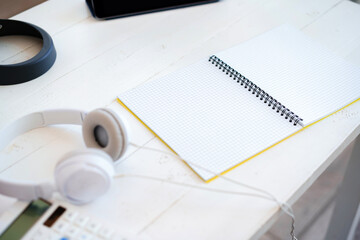 Open blank notepad and headphones on table