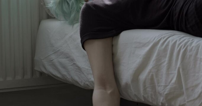Young woman is commiting suicide, Stressed female taking drug overdose lying on bed with suicide note. Desperate, having no meaning of life. Life problem concept. Depression, mental disorders