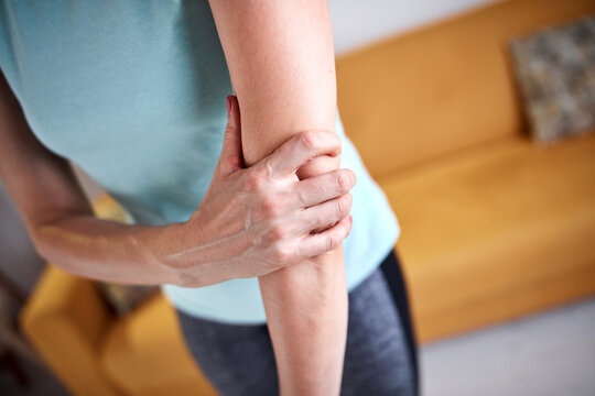 Woman With Hand And Arm Pain At Home.