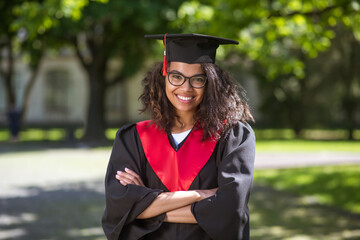 Pretty young girl in academic cap feeling happy about graduation