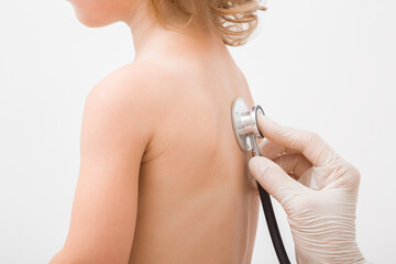 Doctor hand in protective glove holding stethoscope and listening child lungs noise from back....