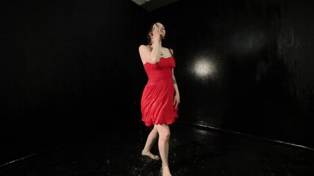 Woman in a red dress is dancing in the water contemporary.
