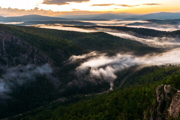 Fog in the mountains at sunrise. Morning fog in the mountains at dawn. Clouds in the mountains. Morning fog after rain. Mountains at dawn. Milk rivers. Copy space