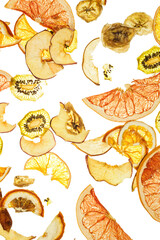 Mix of fruit chips on a transparent white background. Banana, orange, kiwi, grapefruit, apple. Healthy snacks and food.