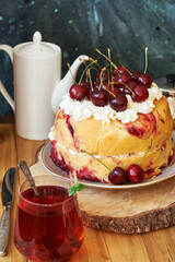 Cherry cake. Yeast bun with cherries and cream. Top view, wooden and blue background.