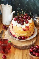 Cherry cake. Yeast bun with cherries and cream. Top view, wooden and blue background.