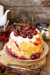 Cherry cake. Yeast bun with cherries and cream. Top view, wooden background.