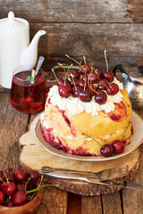 Cherry cake. Yeast bun with cherries and cream. Top view, wooden background.