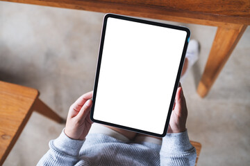 Top view mockup image of a woman holding digital tablet with blank white desktop screen