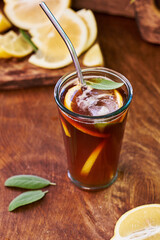 Espresso tonic. Lemon, sage. Side view, wooden background.