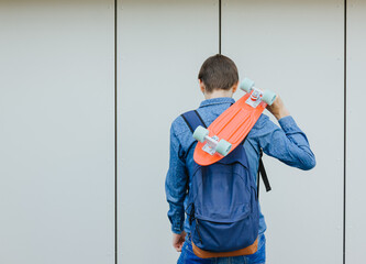 close up stylish man carrying the penny board on the urban background