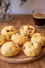 Cottage cheese buns with raisins. Wooden and white background. Side view.