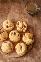 Cottage cheese buns with raisins. Wooden and white background. Side view.