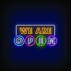 Obraz premium We are Open Neon Signboard On Brick Wall
