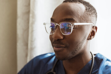 Close-up portrait of african young doctor, therapeutic or medical advisor at work, idoors . Concept of healthcare, care, medicine and professional occupation