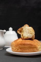 Homemade eclair cut with filling inside. Sweet pastries, close-up. Baking for tea. Vertical frame