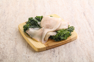 Raw squid over wooden board