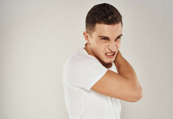 man in white t-shirt emotions irritability light background