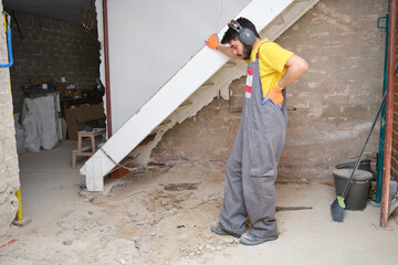 Young builder thinking how to solve a problem at the construction site.