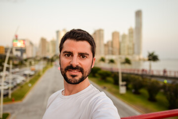 Portrait of young white caucasian male with Panama city skyline and sea in the background