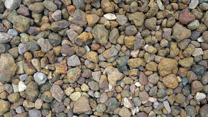 Granite gravel of macadam, Rock brown crushed for construction on the ground, Scree texture background