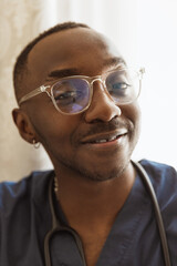 Close-up portrait of african young doctor, therapeutic or medical advisor at work, idoors . Concept of healthcare, care, medicine and professional occupation