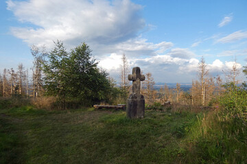 injured nature and the old stone cross on the hiking trail