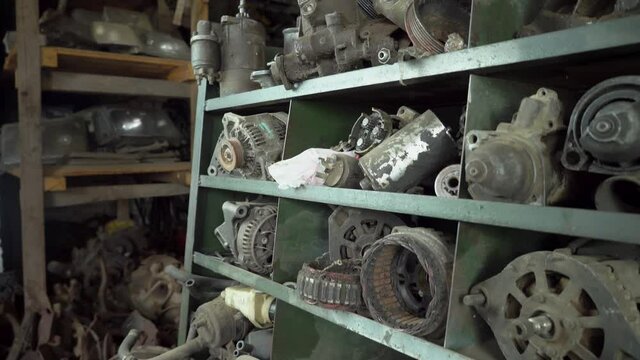 Used car parts on the factory shelf. Used auto parts for sale in a store in a landfill. Bushes, starters, generators, pumps and headlights of passenger cars. Disassembly of cars.