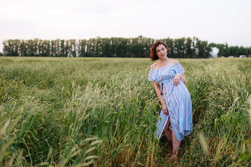 Beautiful young woman in summer in a wheat field