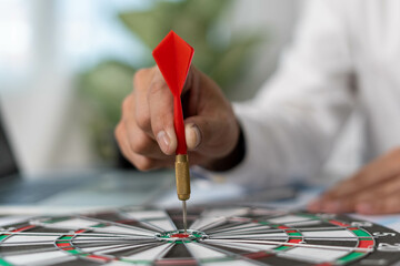 Business men aiming to be successful Business ambitions. Man holds a red darts stabbed to the...