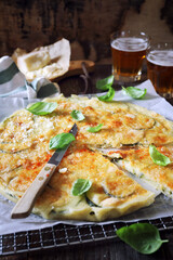  Italian cuisine. Thin zucchini pie with Parmesan cheese, basil dressing and two glasses of beer