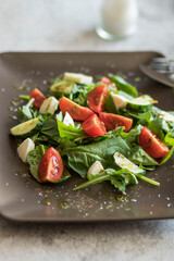 Salad with spinach leaves, arugula, cherry tomatoes, mozzarella and pieces of meat. Diet food. Homemade.