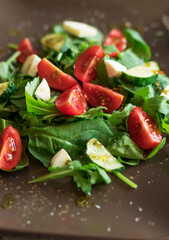 Salad with spinach leaves, arugula, cherry tomatoes, mozzarella and pieces of meat. Diet food. Homemade.