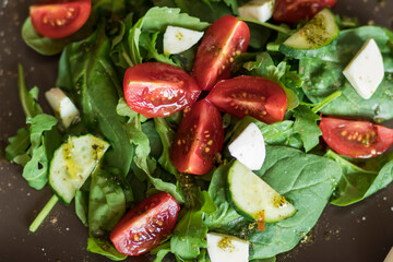 Salad with spinach leaves, arugula, cherry tomatoes, mozzarella and pieces of meat. Diet food. Homemade.