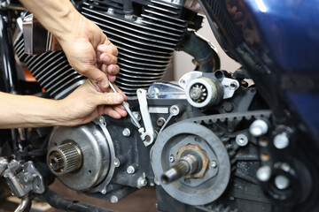 Master repairman repairing motorcycle in workshop closeup